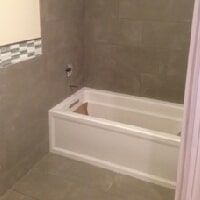 A view of a bathroom having a small bathtub on one side