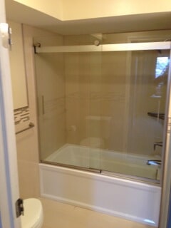 front view of bathtub with closed glass door