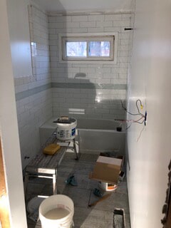 view of electrical wiring and bathtub during renovation