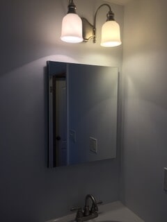 corner view of mirror and lights of bathroom