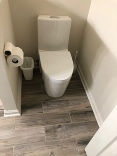 The toilet seat inside a washroom